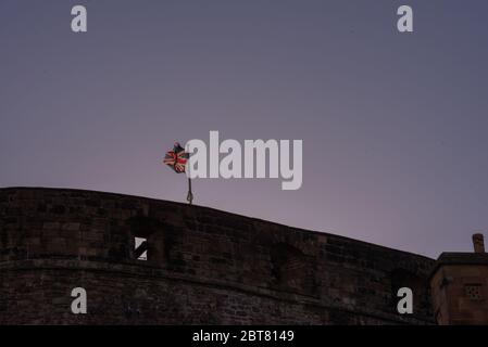 Union jack flag flying during lockdown at Edinburgh Castle at twilight Stock Photo