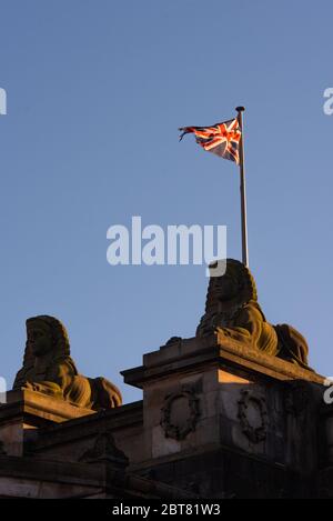 Sphynx on rooftop of National Gallery of Scotland in Edinburgh with Union Jack flag flying against blue sky Stock Photo