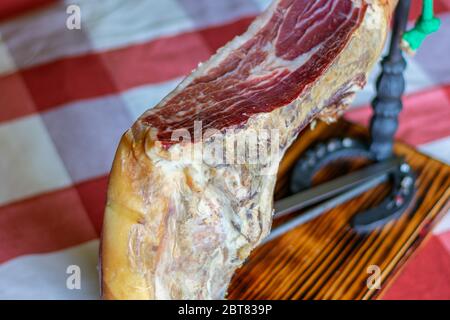 Serrano ham leg on a wooden support and horseshoes Stock Photo