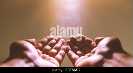 Muslim man praying. Ramadan kareem concept: Muslim prayer open two empty hands up on light background Stock Photo