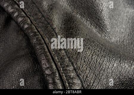 Old vintage genuine soft black leather texture background, top layer with pores and scratches, macro, close-up Stock Photo