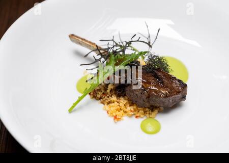 Grilled lamb chop with pesto sauce, international gourmet cuisine a la carte in buffet live station. Using for food and drink industry. Stock Photo