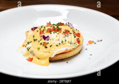 Egg benedict, Poached Egg Royal with Smoked Salmon and Tomato Hollandaise, international gourmet cuisine traditional breakfast of New York. Restaurant Stock Photo