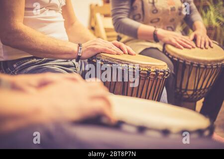Close up of hands on african drums, drumming for a music therapy, therapy by drums Stock Photo