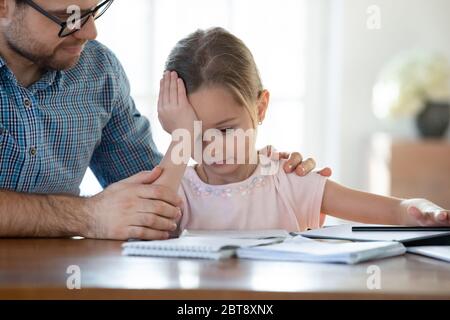 Caring young dad help little daughter with studying Stock Photo