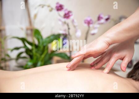 Young woman relaxing during back massage at the spa center Stock Photo