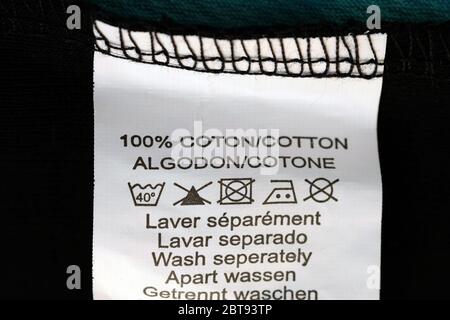 Label with washing instructions. White label with instructions for the composition of the fabric 100% cotton and icons what temperature to wash and ir Stock Photo