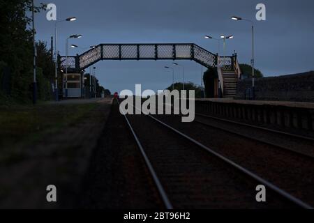 Northern Rail class 156 sprinter train departing from  Kirkby In Furness railway station on the Cumbrian coast railway line at dusk Stock Photo