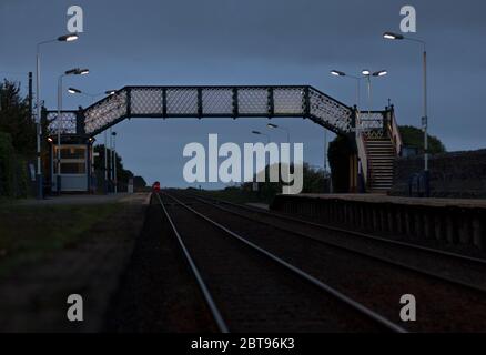 Northern Rail class 156 sprinter train departing from  Kirkby In Furness railway station on the Cumbrian coast railway line at dusk Stock Photo