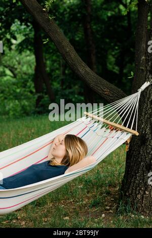 Young woman relaxing in the hammock in nature Stock Photo