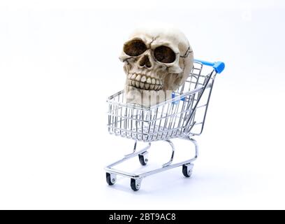 human skull with clearly visible teeth inside the shopping cart on a white background Stock Photo