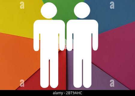 PHOTO of colourful paper in the colours of LGBT flag and two shapes of men. Texture sheets of paper. LGBT concept, symbol of LGBT, Background poster, banner Stock Photo