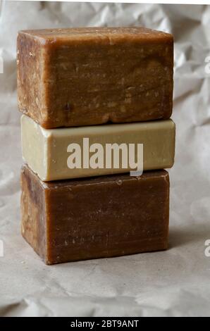 A stack of laundry soap on a beige background. Three different Rectangular pieces of new soap. Natural hygiene products. Place for text. Selective foc Stock Photo