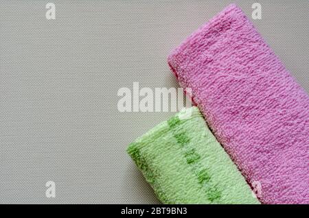 Soft multi-colored towels on a white textured background. Colorful bath towels. Health and hygiene care. View from above. Place for text. Stock Photo