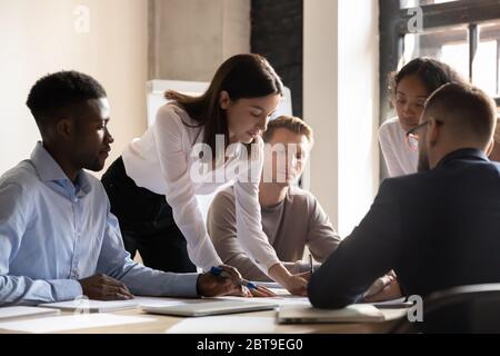 Diverse colleagues working on project together, sitting at table Stock Photo