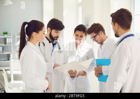 A team of doctors in a meeting discusses the diagnosis of a patient in a clinic office. Teamwork of doctors at the conference of colleagues in the hos Stock Photo