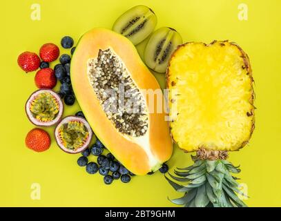 Flat lay of tropical fruits on a yellow background Stock Photo
