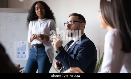 Confident businessman speaking at corporate meeting with business coach Stock Photo