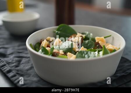 Salad with spinach, kumato tomatoes and cheese in white bowl on linen napkin Stock Photo