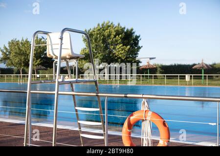Orange lifebuoy floating on the surface of blue water in a pool Stock Photo