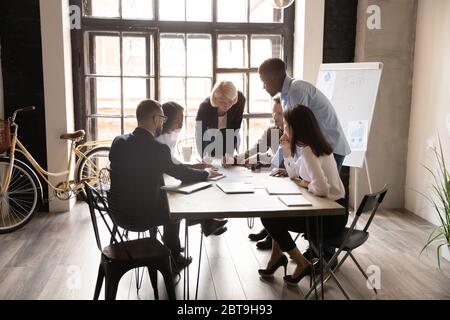 Diverse business team working with project statistics together at meeting Stock Photo