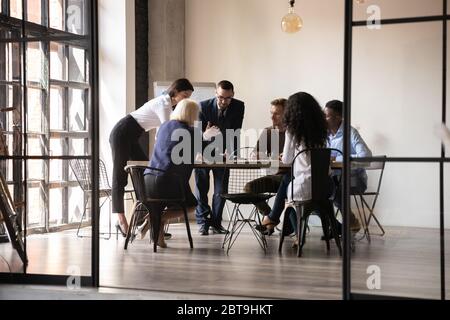 Diverse employees team engaged in teamwork in modern boardroom Stock Photo