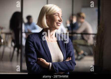 Head shot middle aged businesswoman dreaming about good future Stock Photo