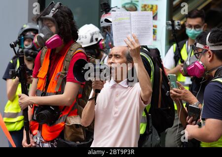 Hong Kong, 24th May 2020. Man on speaker phone talking to the crowd. Credit: David Ogg / Alamy Live News Stock Photo