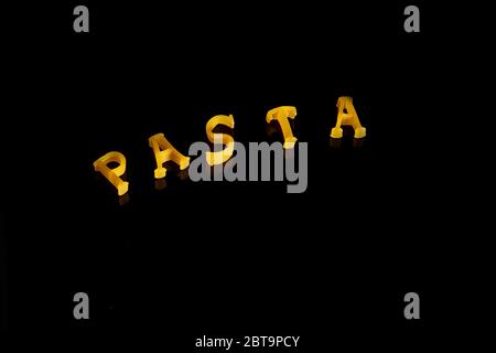 Pasta word made of different types of pasta on black background Stock Photo