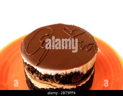Closeup a Tasty Round Shaped Opera Cake Served on Vivid Orange Plate Isolated on White Background Stock Photo