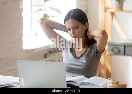 Tired millennial girl exhausted of homework assignment or studying Stock Photo