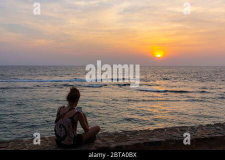 A group of people enjoy the sunset from the fortifications at Galle. Stock Photo