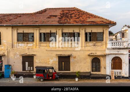 Traffic passes an old building within Galle Fort, in this case the India Hut family restaurant. Stock Photo