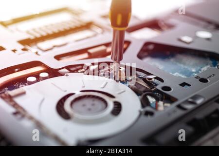 Background close up of laptop computer hardware repairing or diagnostic with screwdriver. Stock Photo