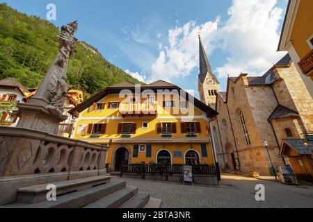 View of the empty market square of Hallstatt, Salzkammergut region, OÖ, Austria, surrounded by historic buildings on a beautiful spring morning Stock Photo