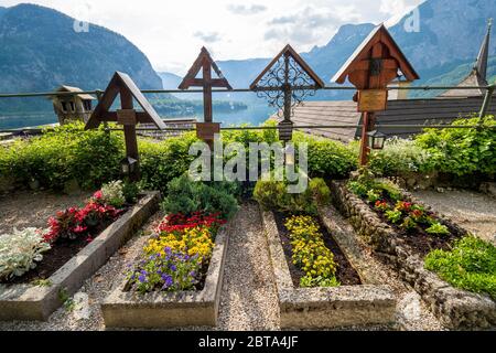 Graves overlooking Lake Hallstatt at the cemetery surrounding the Roman Catholic Parish Church of Hallstatt, Salzkammergut region, OÖ, Austria Stock Photo