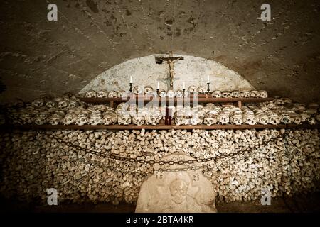 View of hundreds of painted skulls and bones inside the famous charnel house at the mountain village Hallstatt in the Salzkammergut region, Austria Stock Photo