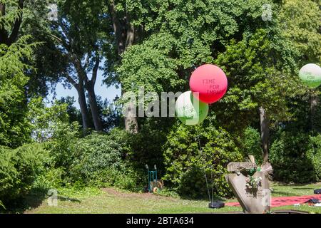 Red and green balloons with text in a garden Stock Photo