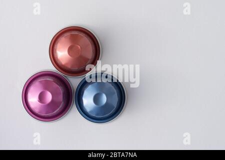 Coffee Capsules in varying colours on a white background viewed from the top. Stock Photo