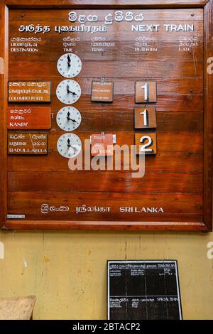 Train to Ella from Nanu Oya station.  Wooden, manually operated departure board at the station. Stock Photo