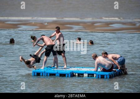 A group of young men enjoy the sunshine in Clevedon Marine Lake in Somerset after lockdown restrictions were eased in England last week. Stock Photo