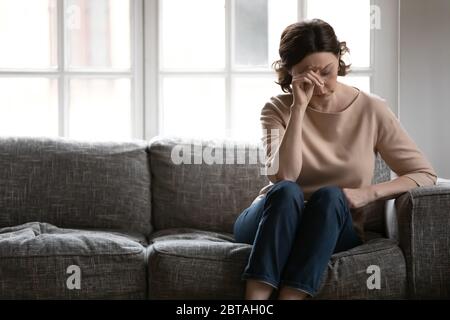 Unhappy mature woman feel anxious lost in thoughts Stock Photo