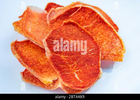 Dried slices of pork, beef with spices on a white background. Crispy meat chips. Delicious appetizer. selective focus Stock Photo