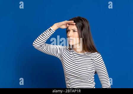 Brunette young woman wearing a striped T-shirt on a blue background Stock Photo