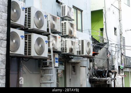 Homes in Asia hung with air conditioning. Hot climate. Narrow streets. The spirit of Asia Stock Photo