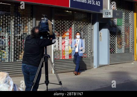 A mask wearing Brazilian TV Globo news reporter Tiago Eltz about to record a coronavirus COVID-19 related news story in New York Stock Photo
