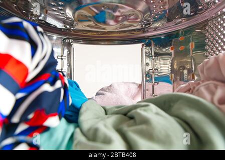 Washing machine with dirty clothes inside, studio shot. photo from inside the washing machine Stock Photo