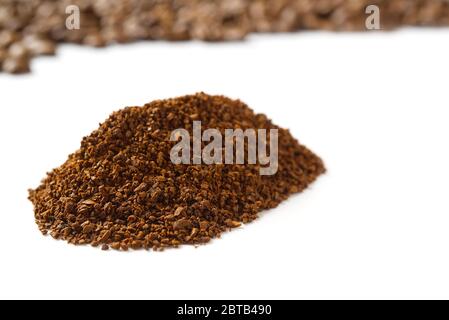 Pile of the ground coffee flakes isolated over the white background. pile of melted coffee Stock Photo