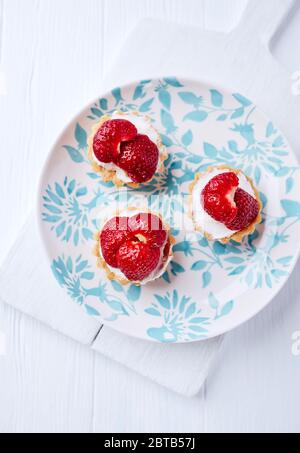 Little mascarpone tart with fresh strawberries on wooden background. Top view. Stock Photo