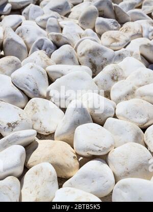 White pebbles texture, background. Natural gravel material for interior decoration or landscaping, vertical photo Stock Photo